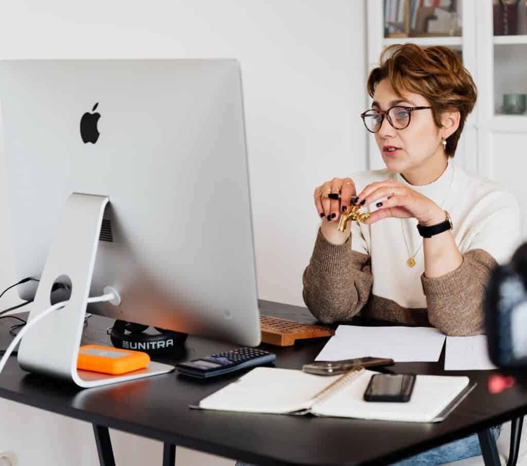 An image of a woman on her computer interacting with an AI Coach.